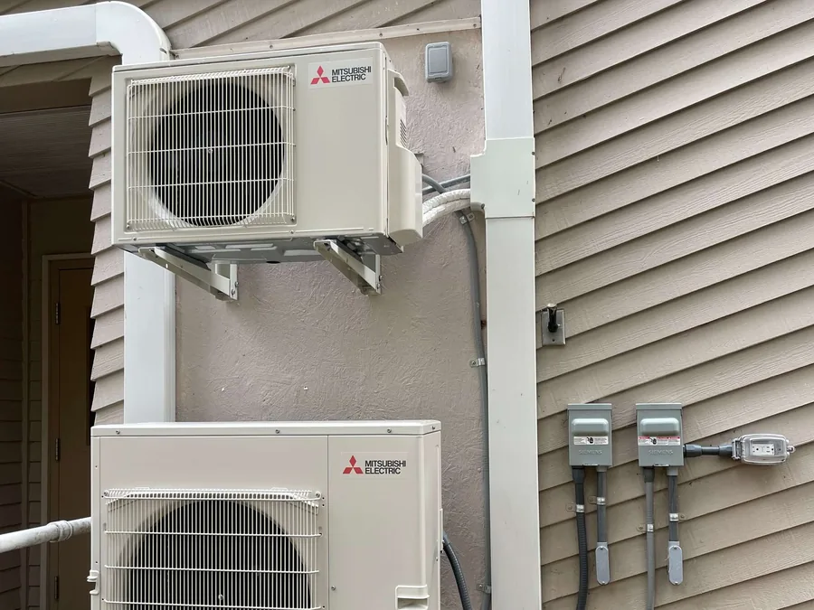 Two Mitsubishi ductless mini split outdoor units installed on the side of a Seattle area home.