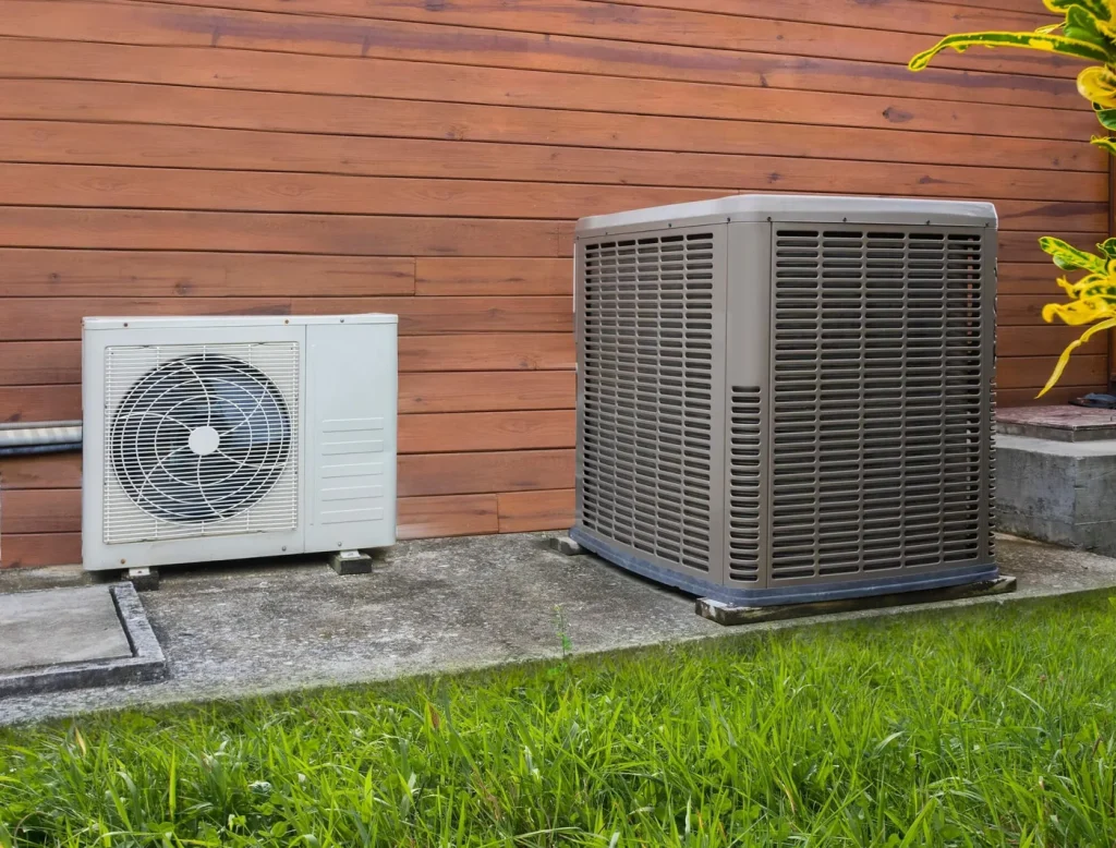 Heat pump and air conditioner condenser installed along a cedar fence at a Washington home.