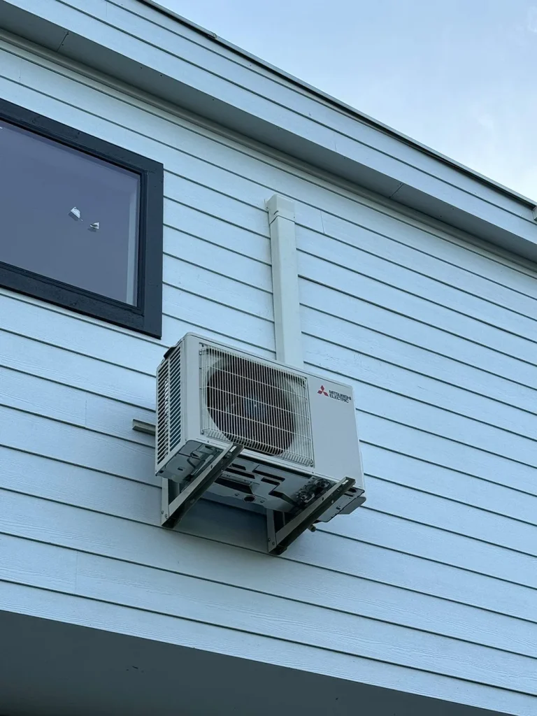Mitsubishi ductless mini split outdoor unit wall mounted on a Seattle area home.